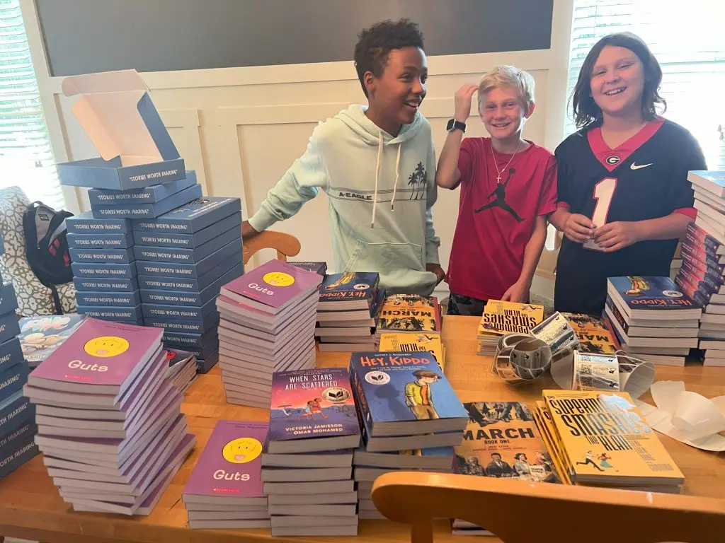 kids smiling at a table full of books
